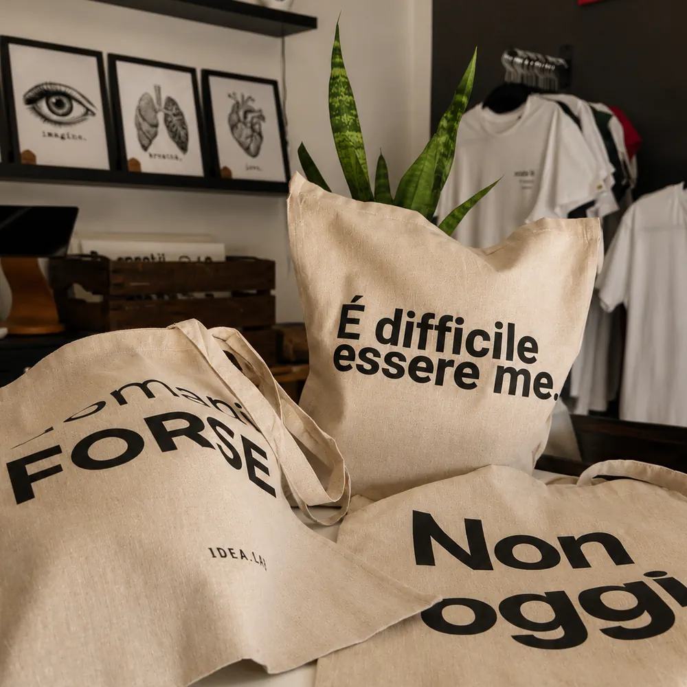 Shopper personalizzate con grafiche originali Idea.lab esposte nel laboratorio artigianale.