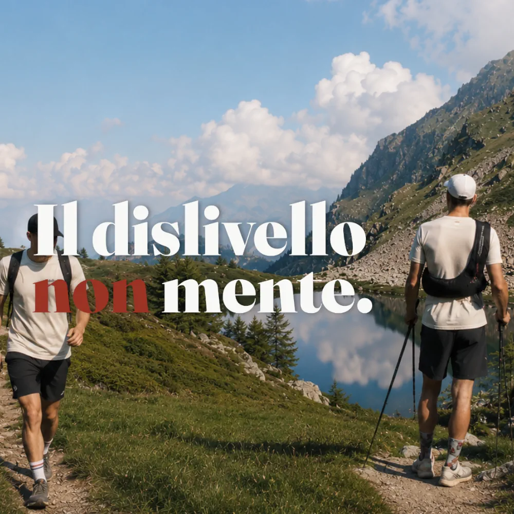 Due trail runner sul sentiero di montagna con magliette della collezione Trail Therapy davanti a un lago alpino.